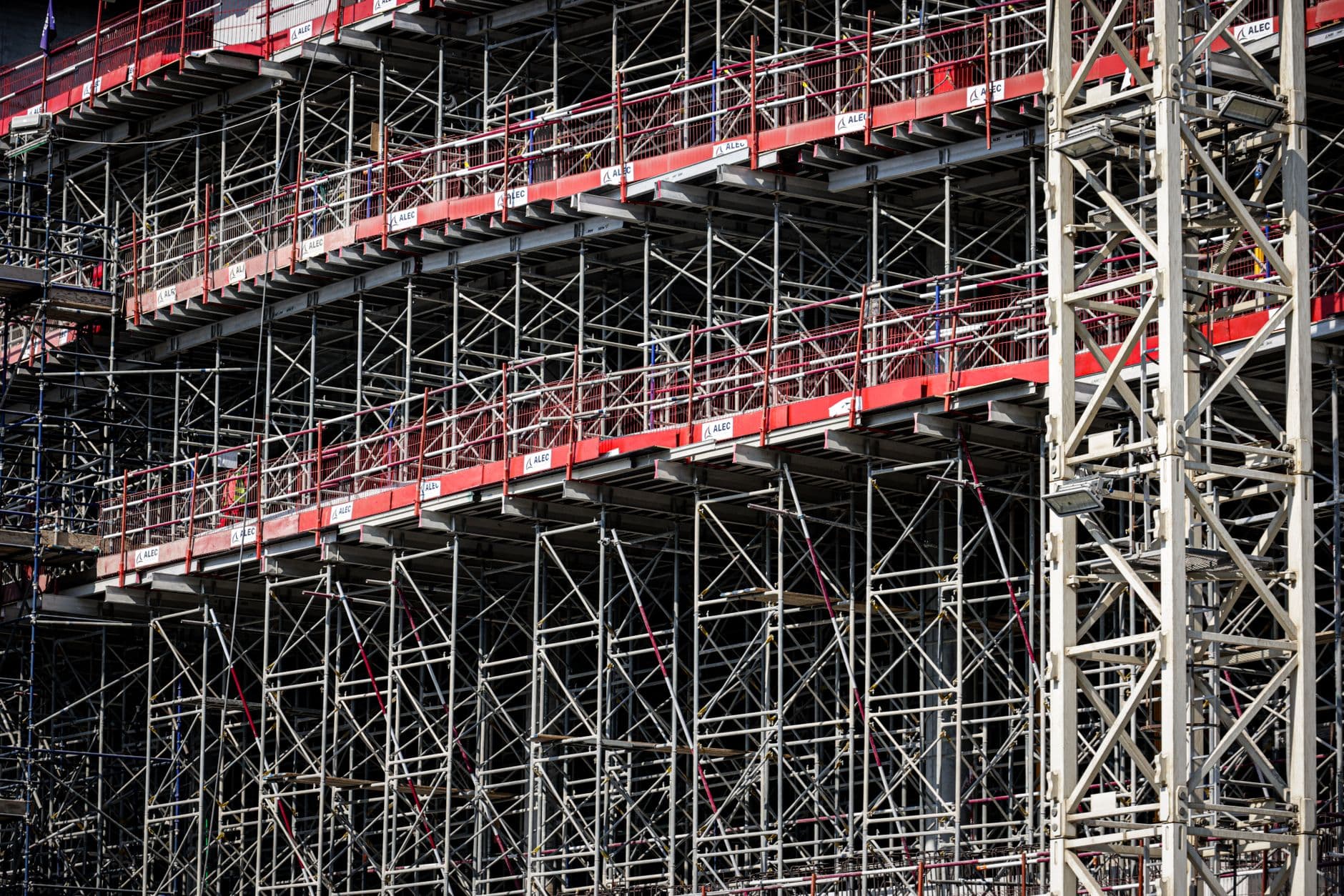 Workers on a properly erected scaffold with guardrails on a construction site